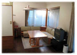 リビングのソファとテーブル。キッチンとベッドも横にあります。